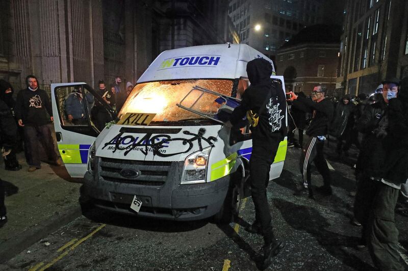 Protesters set fire to a vandalised police van outside Bridewell Police Station, in Bristol. AP Photo