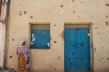 A woman leans on the wall of a house that was shelled as federal-aligned forces entered the city of Wukro, Tigray, Ethiopia. AFP 