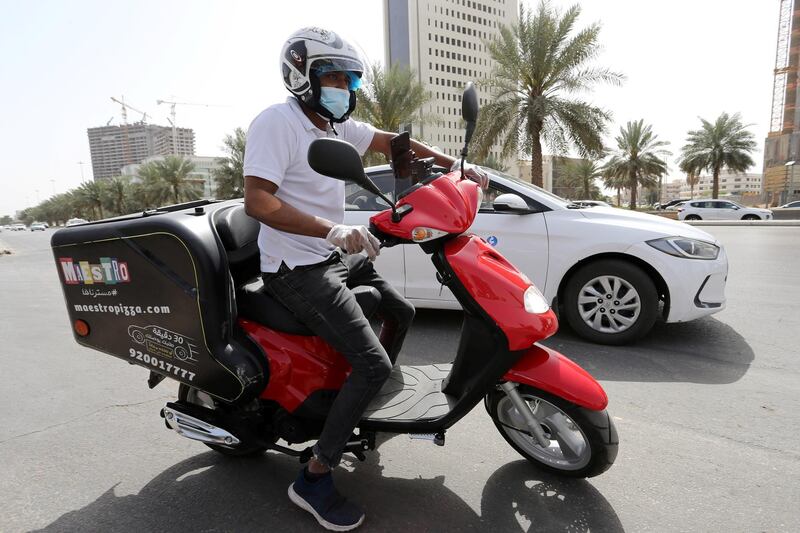 Delivery men wear protective face masks as they deliver food for customers in Riyadh, Saudi Arabia. Reuters
