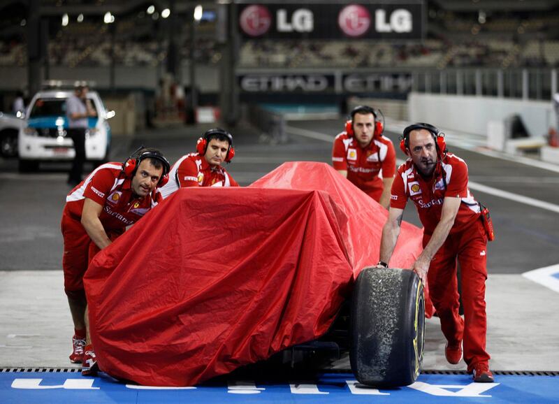 Pit crew members for the Ferrari Formula One team bring in the car of Fernando Alonso of Spain after he crashed during the second practice session of the Abu Dhabi F1 Grand Prix at Yas Marina circuit in Abu Dhabi November 11, 2011. REUTERS/Hamad I Mohammad (UNITED ARAB EMIRATES - Tags: SPORT MOTORSPORT) *** Local Caption ***  ABD29_MOTOR-RACING-_1111_11.JPG