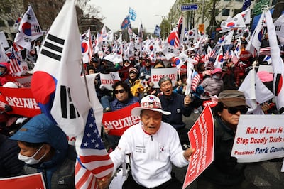 Supporters of former South Korean President Park Geun-hye hold signs and flags as they gather for a protest outside the Seoul Central District Court in Seoul, South Korea, on Friday, April 6, 2018. Park, South Korea’s first female president, was found guilty of crimes ranging from coercion to abuse of power and the leaking of state secrets. Photographer: SeongJoon Cho/Bloomberg