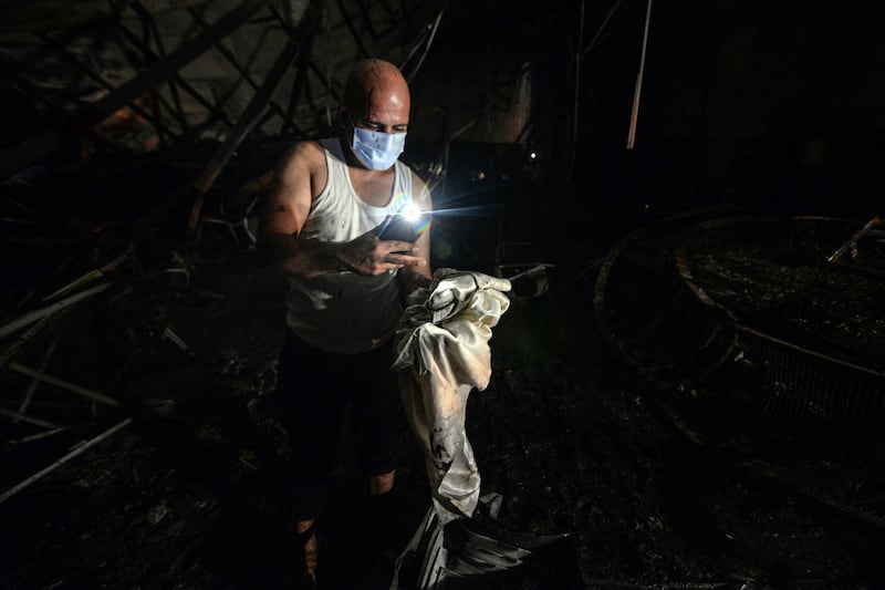 A man searching through debris after the fire. AFP