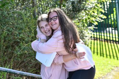 STALYBRIDGE, ENGLAND - AUGUST 20: Katie Hilton and Anna Harding embrace as pupils receive their GCSE results at Copley Academy on August 20, 2020 in Stalybridge, England. Due to new restrictions recently introduced in Tameside and Oldham, pupils are collecting results on an one-to-one appointment only basis. GCSE students were unable to sit their exams this year due to the coronavirus pandemic. A government-backed algorithm used to award grades has been withdrawn after thousands of A'level students were downgraded to the predicted grades given by teachers. (Photo by Anthony Devlin/Getty Images)