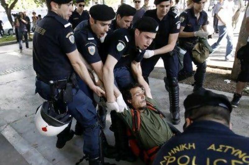 Greek police detain an anti-austerity protester during an operation to remove a small group of European demonstrators from central Syntagma square in Athens.