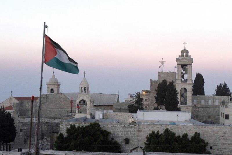 The Palestinian flag flutters in front of the Church of the Nativity, the traditional birthplace of Jesus Christ, in the biblical West Bank town of Bethlehem. MUSA AL SHAER / AFP