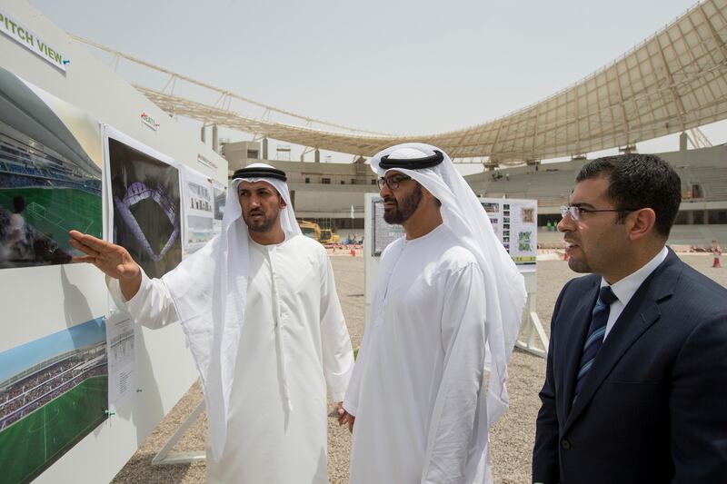 AL AIN, EASTERN REGION OF ABU DHABI, UNITED ARAB EMIRATES - May 08, 2013: HH General Sheikh Mohamed bin Zayed Al Nahyan Crown Prince of Abu Dhabi Deputy Supreme Commander of the UAE Armed Forces (2nd L), looks at illustrations of the Hazza Bin Zayed Stadium, which will serve as the new home ground of Al Ain Football Club. Seen with  HE Mohamed Mubarak Al Mazrouei Under-Secretary of the Crown Prince Court of Abu Dhabi (L), and Kareem Nagy Hassan CEO of Al Qattara Investments (R)..( Ryan Carter / Crown Prince Court - Abu Dhabi ).---