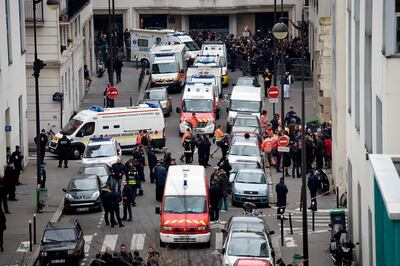 (FILES) This file photo taken on January 7, 2015 shows a general view of firefighters, police officers and forensics gathered in front of the offices of the French satirical newspaper Charlie Hebdo in Paris, after the brothers Kouachi stormed the offices leaving twelve dead.  The trial of the January 2015 attacks on Charlie Hebdo, Montrouge and Hyper Cacher will take place from September 2 to November 10, 2020 in Paris. / AFP / Martin BUREAU
