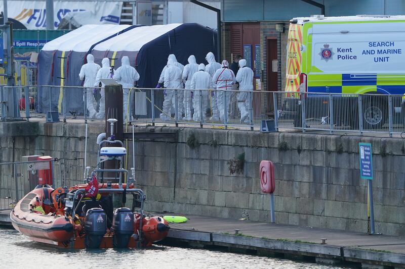 Forensics officers gather at the Port of Dover, where a body bag was brought ashore. PA
