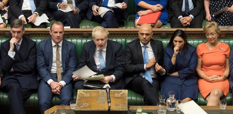 In this image released by the House of Commons, new British Prime Minister Boris Johnson, third left, sits with his front bench and other Conservative lawmakers in Parliament in London, Thursday, July 25, 2019. From left they are: Jacob Rees-Mogg, Dominic Raab, Johnson, Sajid Javid, Priti Patel and Andrea Leadsom. (Jessica Taylor/House of Commons via AP)