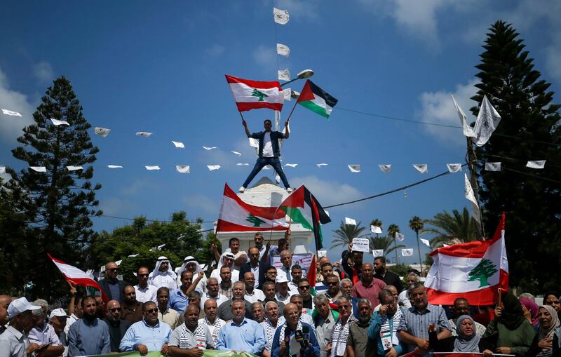 Palestinians hold Lebanese flags as they gather to show solidarity with the Lebanese people following the huge explosions in Beirut's port area, in Gaza City, on August 6, 2020. / AFP / MOHAMMED ABED
