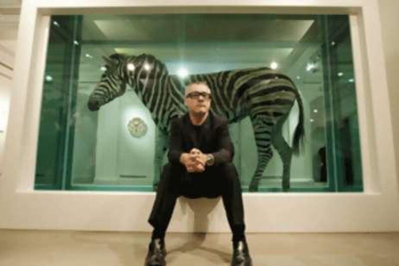 The British artist Damien Hirst poses in front of his work <i>The Incredible Journey</i> at Sotheby's art gallery and auction house in London.