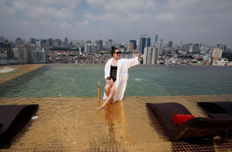 A woman poses for a photo at the gold-plated infinity pool of Dolce Hanoi Golden Lake luxury hotel. Reuters