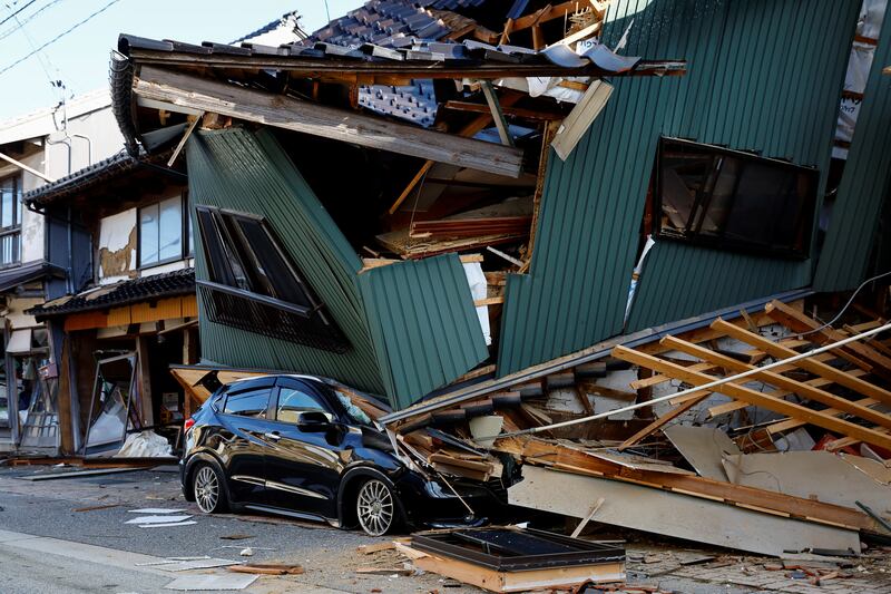 A damaged car stands near a collapsed house, following an earthquake, in Nanao, Ishikawa prefecture. Reuters