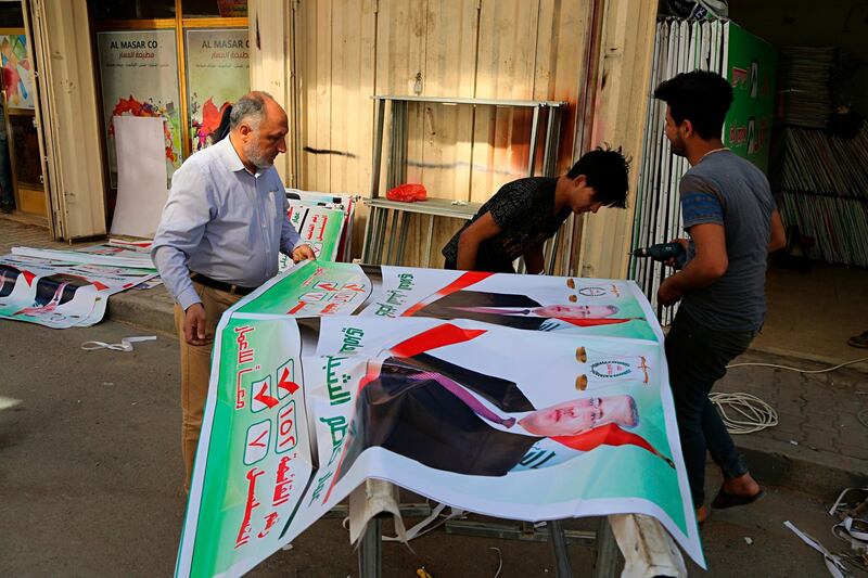 In this March 18, 2018 photo, Iraqis prepare an election banner in Baghdad, Iraq. Iranâ€™s influence is looming large as Iraqis prepare to head to the polls for parliamentary elections in May, with many concerned that Tehran may be looking to strengthen its political grip on Baghdad in the vote. (AP Photo/Karim Kadim)