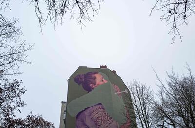 A giant mural painting, titled 'Absent', depicts a Ukrainian woman embracing a vanishing figure on the side of a building in Berlin on Saturday. AFP