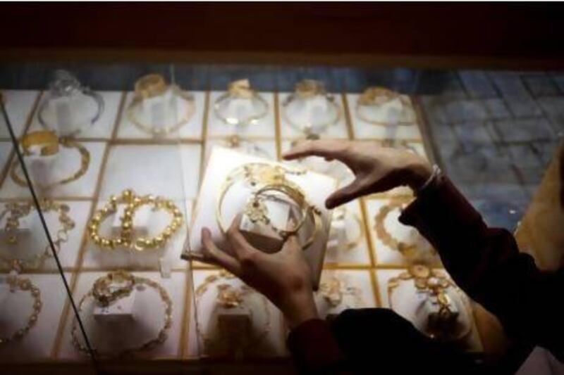 Toufiq Ahmed, a salesman from Bangalore arranges gold necklaces and jewelry sets at the storefront of Kanz Jewels at the Gold Souk in Deira. Razan Alzayani / The National