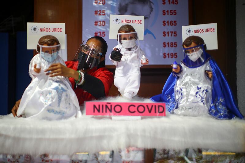 A saleswoman adjusts the suit of a dressed-up doll representing baby Jesus and wearing a face mask to promote the use of masks as a precautionary measure amid the coronavirus disease outbreak before Christmas celebration, inside a store in Mexico City, Mexico. Reuters
