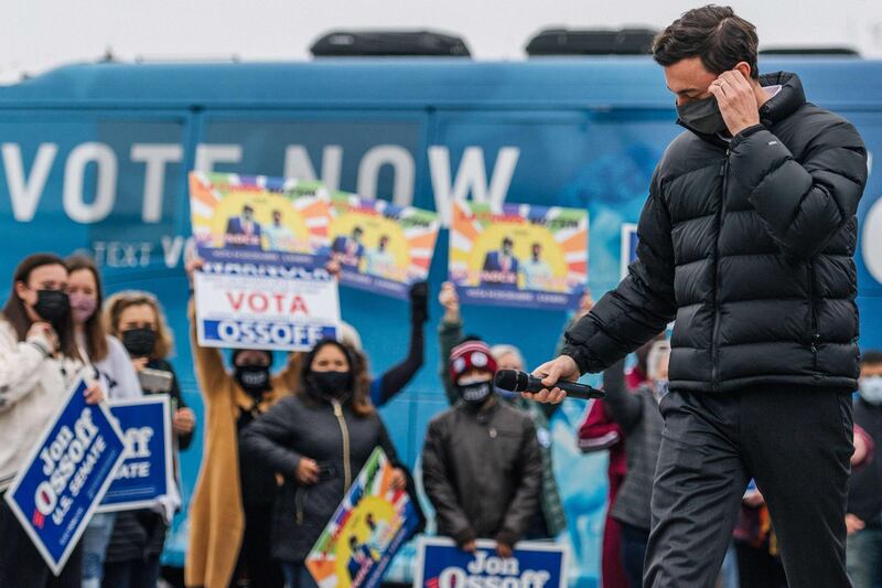 Senate candidate Jon Ossoff removes his mask before speaking at a literature distribution rally in Marietta, Georgia. AFP