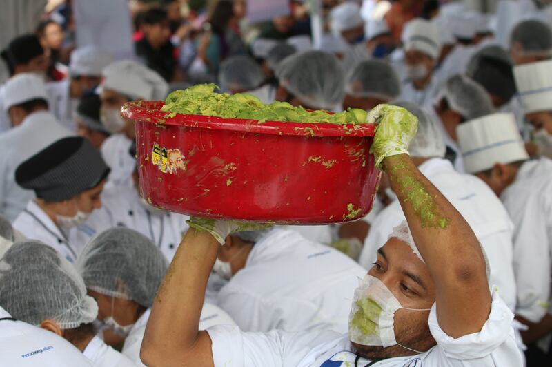 A volunteer from a culinary school carries a bowl of guacamole as he attempts with others to set a new Guinness World Record for the largest serving of guacamole in Concepcion de Buenos Aires, Jalisco, Mexico September 3, 2017. REUTERS/Fernando Carranza