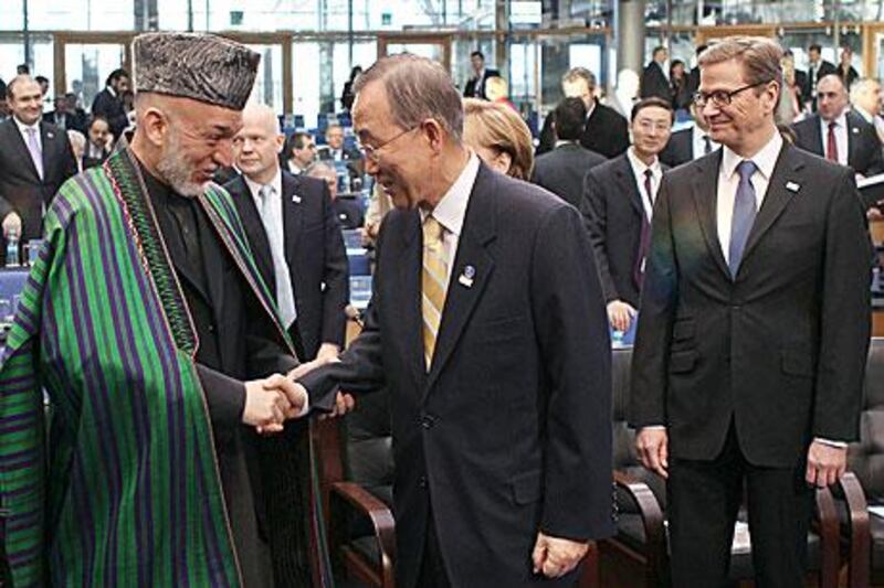 The president of Afghanistan Hamid Karzai, left, shakes hands with the UN secretary general,  Ban Ki-moon. Karzai says his country will need help “for at least another decade”.