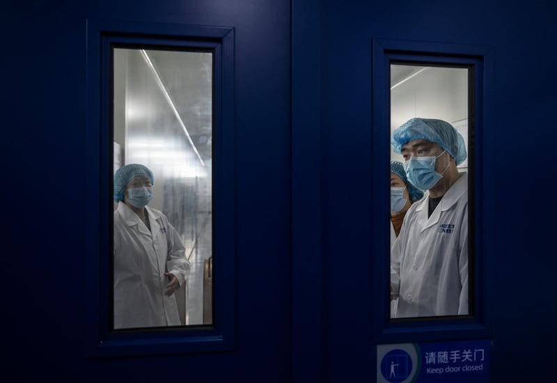 Workers wait to enter the packaging area of Sinopharm's Covid-19 vaccine production centre in Beijing. Getty