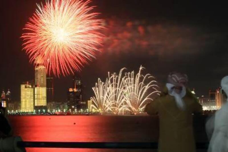 People watch a fireworks display on Abu Dhabi Corniche. Officials have warned people against buying illegal fireworks and advised families to attend organised displays in the run up to Eid Al-Fitr. Ravindranath K / The National
