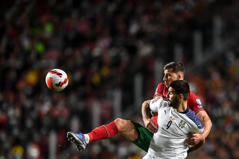 Portugal defender Ruben Dias fights for the ball with Serbia forward Aleksandar Mitrovic. AFP