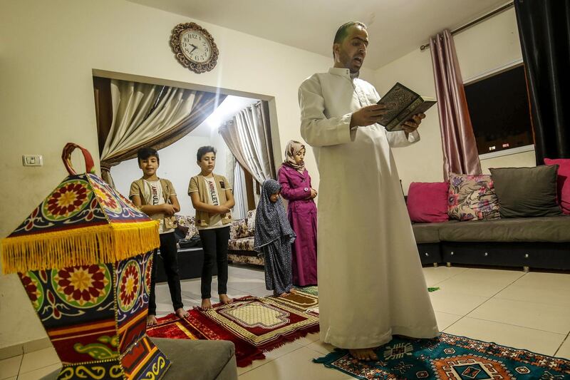A Palestinian family perform the tarawih special prayer during the first day of Ramadan in their home in Khan Yunis in the southern Gaza Strip on April 24, 2020. AFP