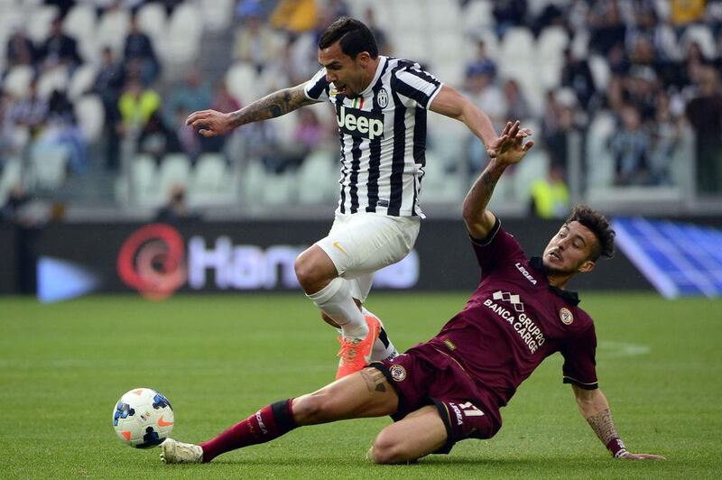 Juventus' Argentine foward Carlos Tevez, left, vies for the ball with Livorno's Italian defender Federico Ceccherini during the Italian Serie A match in Turin, northern Italy. Olivier Morin / AFP