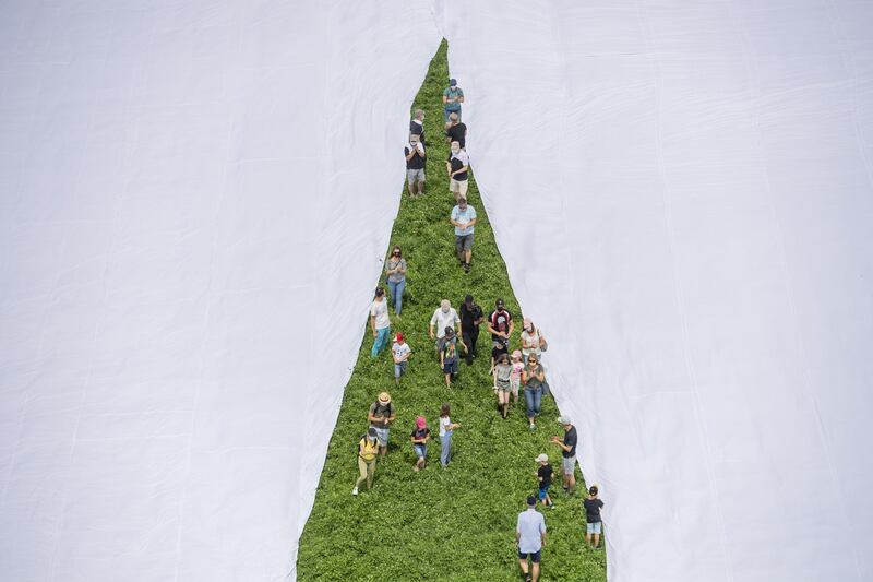 An inside leg view of the giant trousers being unfurled. Xwendekar Kelesh, who fled Syria to Switzerland 11 years ago, said the giant trousers are intended to draw attention to plastic pollution. EPA