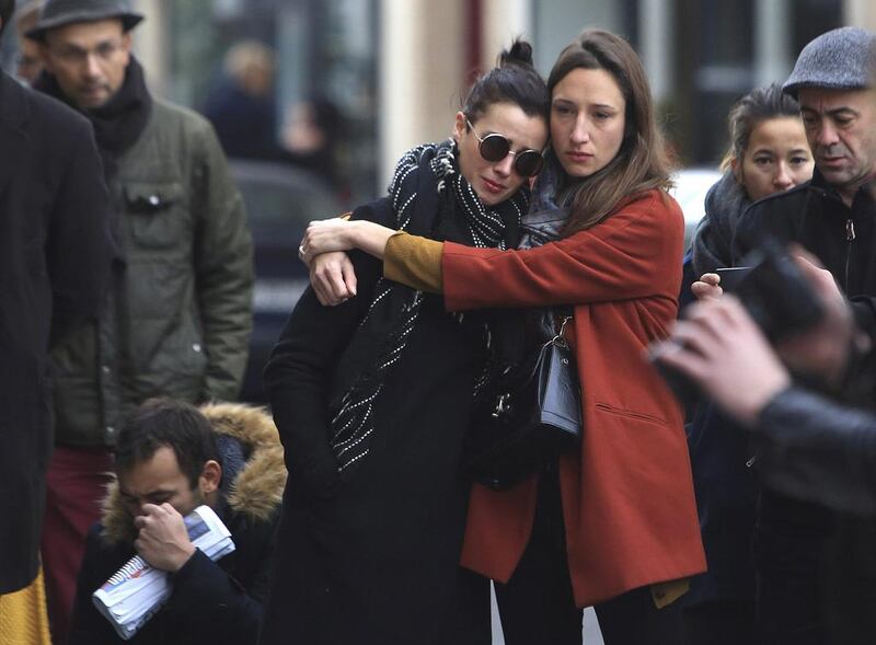 Women comfort each other as they stand in front of the Carillon cafe, in Paris. Thibault Camus / AP Photo