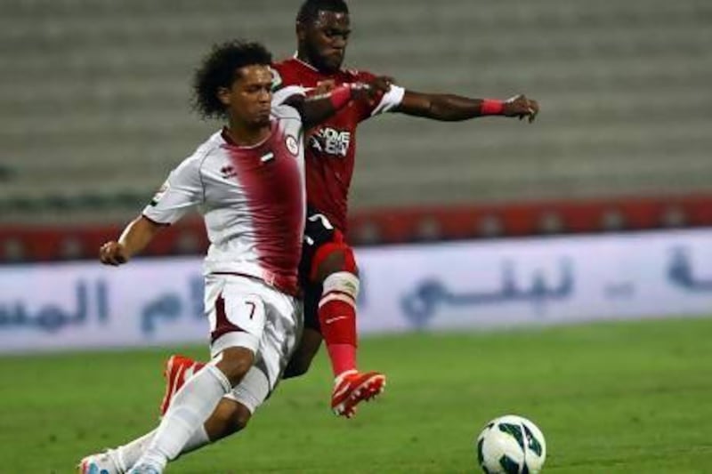 Al Wahda’s Mohamed Al Shehhi, left, tries keeping Ismail Al Hammadi of Al Ahli off the ball.