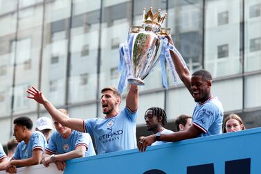 MANCHESTER, ENGLAND - MAY 23: Ruben Dias and Luke
Mbete-Tabu of Manchester City lift the Premier League trophy on the parade bus during the Manchester City FC Victory Parade on May 23, 2022 in Manchester, England. (Photo by Lewis Storey / Getty Images)
