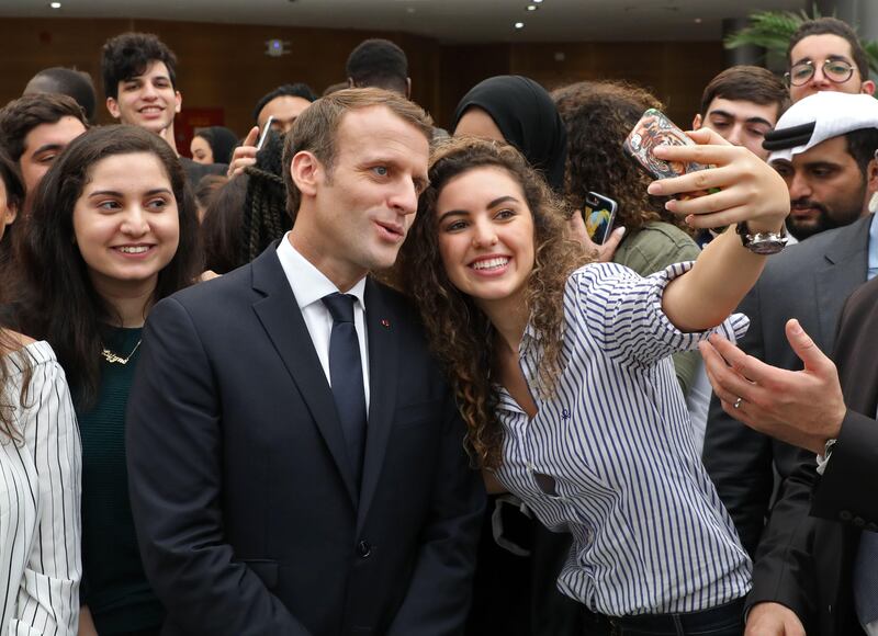 French President Emmanuel Macron poses for selfies with students at Paris-Sorbonne University Abu Dhabi.  Ludovic Marin / AFP Photo