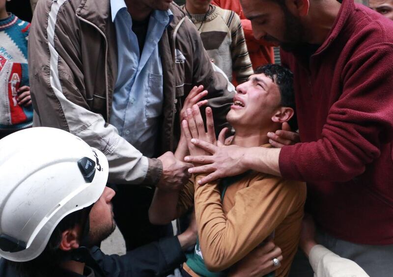 A man is comforted by a rescue worker following a reported air raid by government forces in the northern city of Aleppo, Syria. Fadi Al-Halabi / AFP Photo