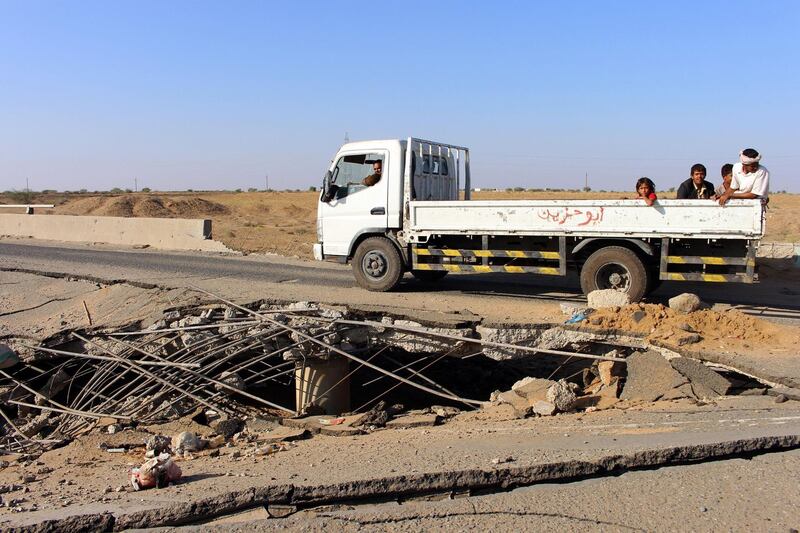 Yemenis on the back of a pick up truck drive past the damage made by a Saudi-led airstrike on a bridge between the area of Abbas and Harad in the northern province of Hajjah, on December 25, 2017.
Fresh air strikes and clashes in Yemen have killed over 60 fighters as Saudi-backed pro-government forces push an offensive against Huthi rebels, security and medical sources said. / AFP PHOTO / STR