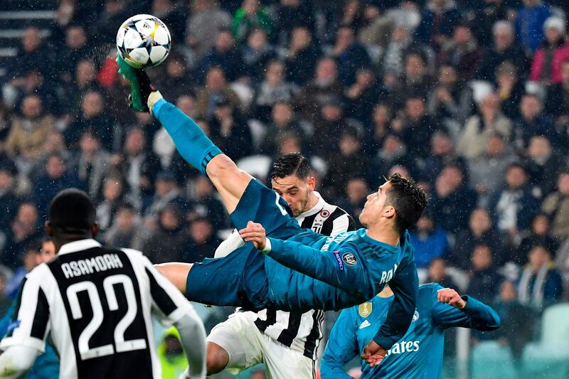 (FILES) In this file photo taken on April 03, 2018 Real Madrid's Portuguese forward Cristiano Ronaldo (C) overhead kicks and scores during the UEFA Champions League quarter-final first leg football match between Juventus and Real Madrid at the Allianz Stadium in Turin on April 3, 2018. Real Madrid announced on July 10, 2018 the transfer of Cristiano Ronaldo to Italy's Juventus, with the Portuguese superstar saying the time had come "for a new stage" in his life. / AFP / Alberto PIZZOLI
