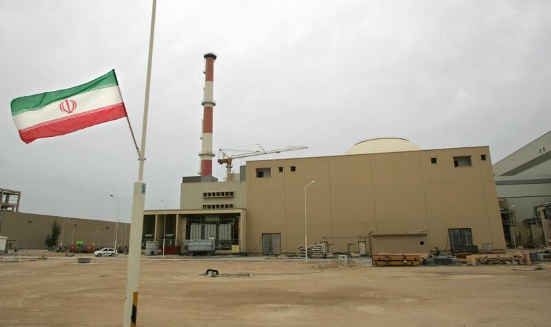 (FILES) This file photo dated April 3, 2007 shows an Iranian flag outside the building housing the reactor of the Bushehr nuclear power plant in the southern Iranian port town of Bushehr, 1200 Kms south of Tehran. Iran will "automatically" return to its nuclear commitments if US President-elect Joe Biden lifts sanctions imposed in the past two years, its foreign minister said on November 18, 2020. Tehran again meeting its commitments "can be done automatically and needs no conditions or even negotiations," Mohammad Javad Zarif said in comments published in the state-run Iran daily. / AFP / BEHROUZ MEHRI
