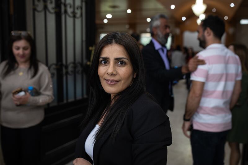 Hweida Al Halabi, who works in a medical laboratory, stands outside the hall in Kfeir after a meeting with Mr Hamdan.
