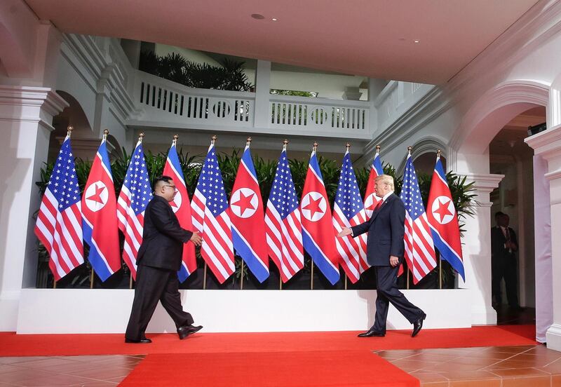 epaselect epa06801414 US President Donald J. Trump (R) and North Korean leader Kim Jong-un (L) walk towards each other to shake hands at the start of a historic summit at the Capella Hotel on Sentosa Island, Singapore, 12 June 2018. The summit marks the first meeting between an incumbent US President and a North Korean leader.  EPA/KEVIN LIM / THE STRAITS TIMES   EDITORIAL USE ONLY