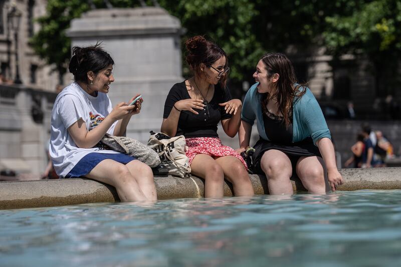 Women enjoy the afternoon sun in Trafalgar Square in London.  Getty Images