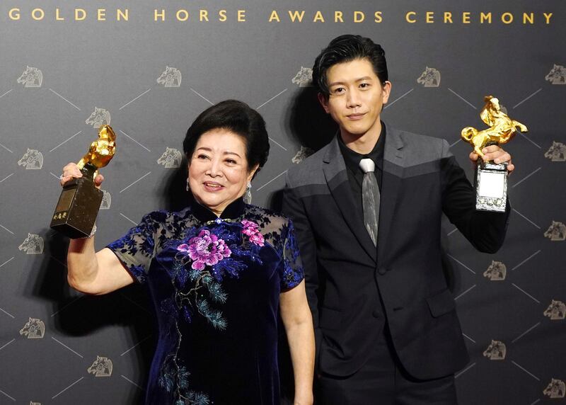 Taiwanese actors Chen Shu-fang, left, and Mo Tzu-yi hold their awards for Best Leading Actress and Best Leading Actor at the 57th Golden Horse Awards in Taipei, Taiwan, Saturday, Nov. 21, 2020. Golden Horse Awards is considered Asia's equivalent of the Academy Awards for Chinese-language films. (AP Photo/Billy Dai)