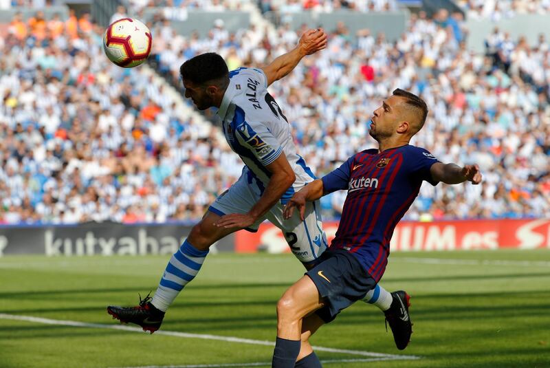 Real Sociedad's Joseba Zaldua leaps for the ball ahead of Barcelona's Jordi Alba. Reuters