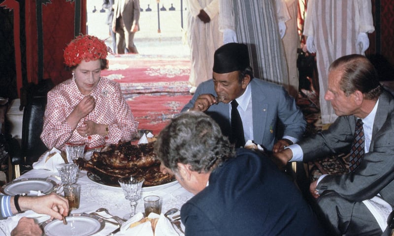 MOROCCO - OCTOBER 27:  Queen Elizabeth II,  Prince Philip, Duke of Edinburgh and King Hassan ll eat with their hands as they attend a feast in the desert on October 27, 1980 in Morocco. (Photo by Anwar Hussein/Getty Images)