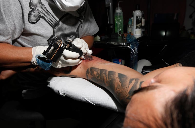 Dubai, 17th January 2012.  Lupin the Tattoo Artist etching Martin Luther King's image to Lawrence Talento's ( 24 years old and a Filipino ) tricep's.  ( Jeffrey E Biteng / The National )