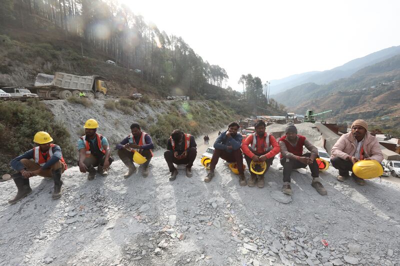 Workers gather near the site of a tunnel collapse as they wait for instructions to continue with rescue operations in Uttarkashi, India. EPA