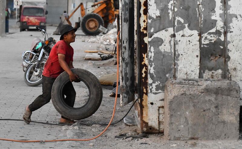 A young Syrian boy works at a tyre repair shop in the town of Jandaris, in the countryside of the north-western city of Afrin in the rebel-held part of Aleppo province, a day before the annual World Day Against Child Labour.