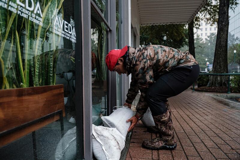 A man sandbags the doorway to a hair salon as rain from Hurricane Delta falls in Lafayette, Louisiana, USA.  EPA