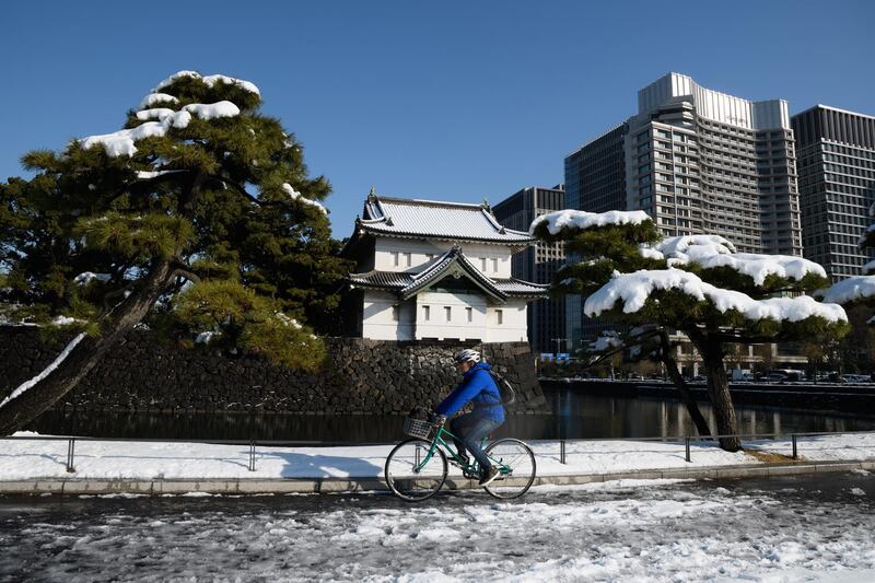 A man rides a bicycle past the Imperial Palace as snow covers the ground in Tokyo on Tuesday. Akio Kon / Bloomberg