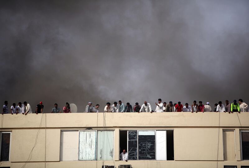 May 7, 2012 (Au Dhabi) People look down off the roof as fire fighters battle a apartment fire happening a few floors down on Airport Road and 13th Street in Abu Dhabi May 7, 2013. (Sammy Dallal / The National)